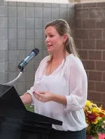 Woman speaking into podium microphone.